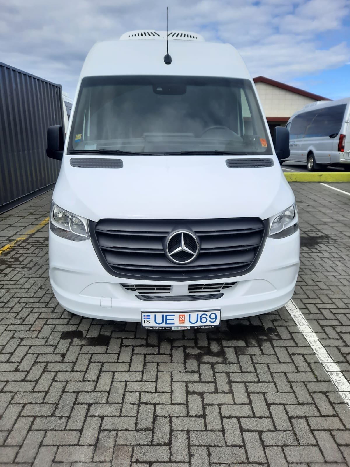 White Mercedes-Benz Sprinter minibus on an Icelandic depot forecourt