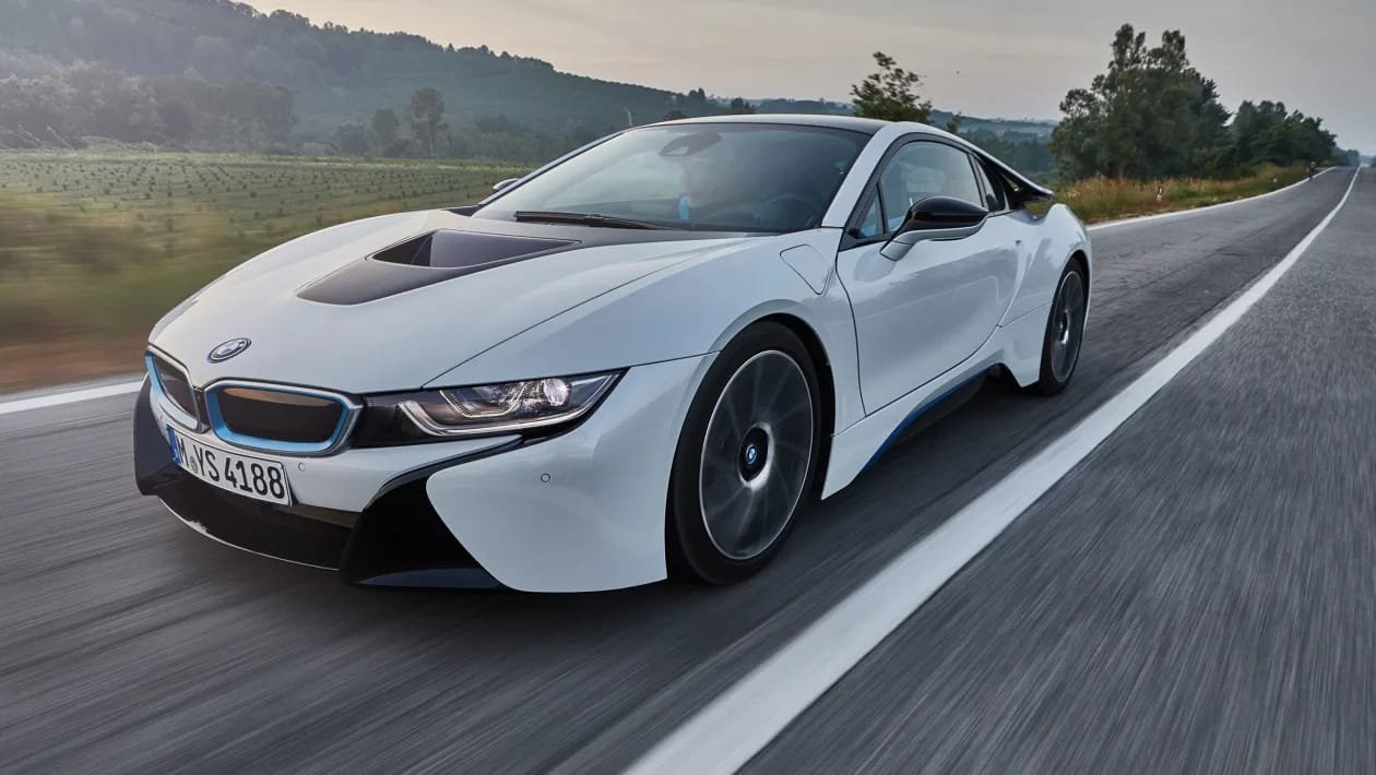White BMW i8 driving an open country road