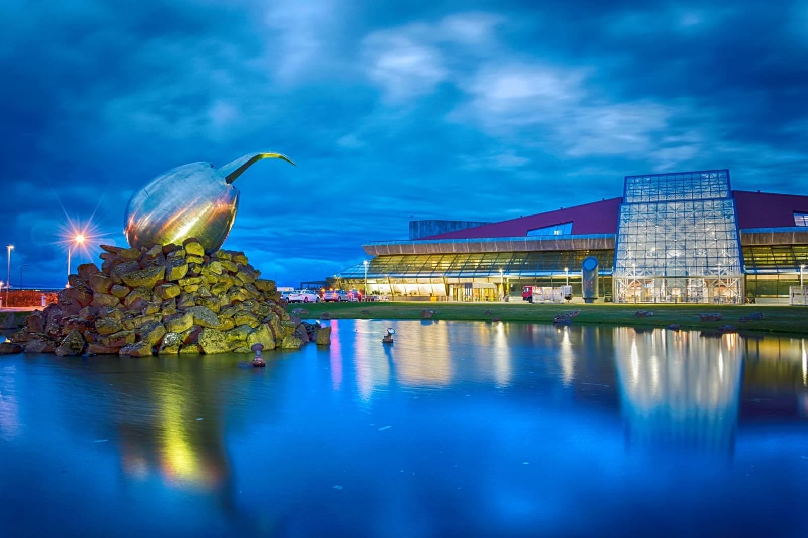 The Jet Nest sculpture and glass terminal of Keflavík International Airport at blue hour