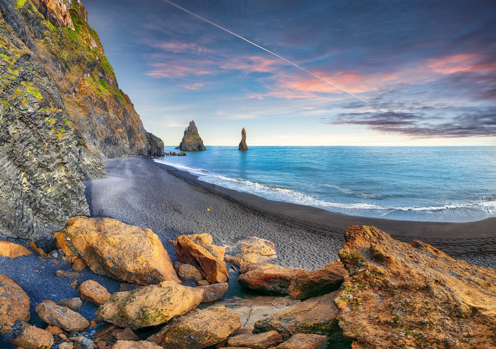 Reynisdrangar basalt sea stacks rising from the ocean off the black sand coast