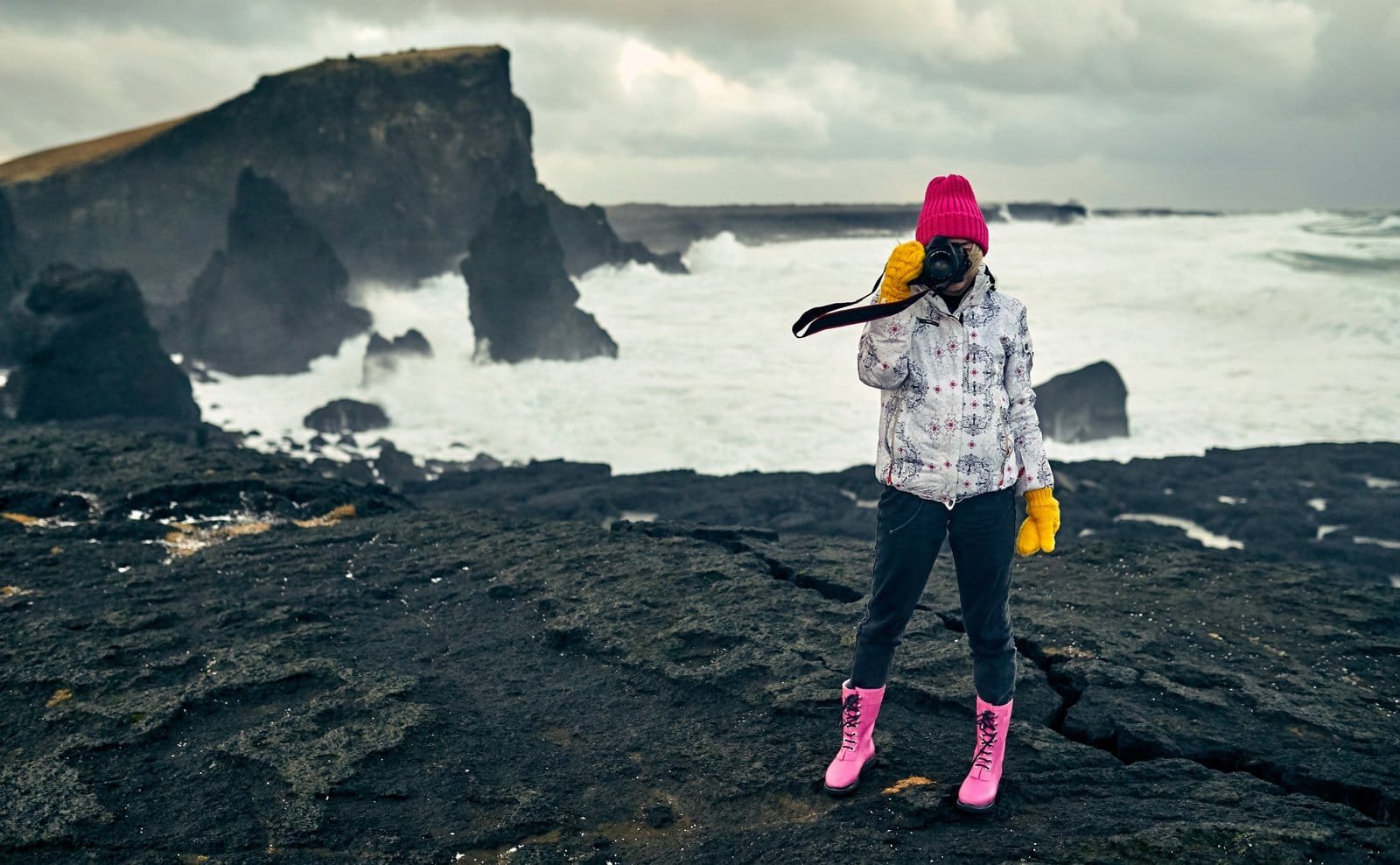 Traveler overlooking a snow-dusted mountain valley on Iceland’s South Coast