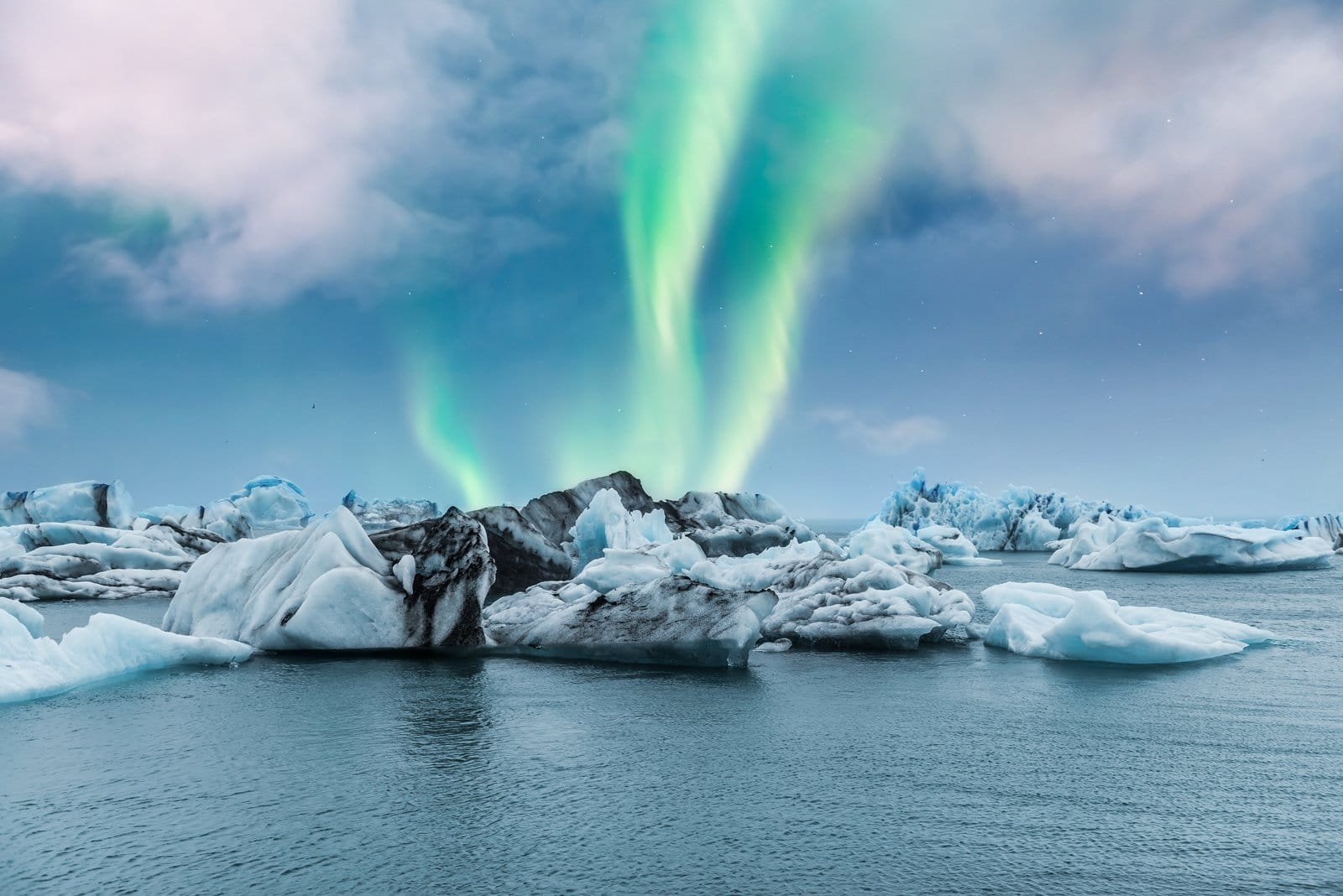 Northern lights arcing over Jökulsárlón glacier lagoon at night