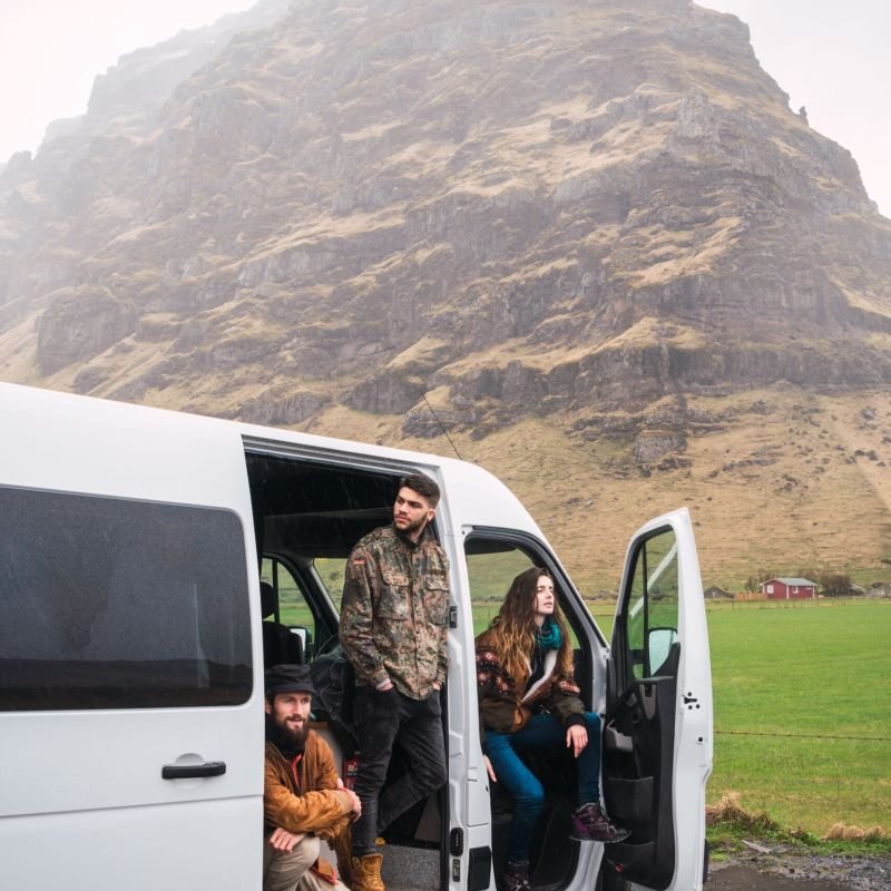 Laughing friends with van in nature